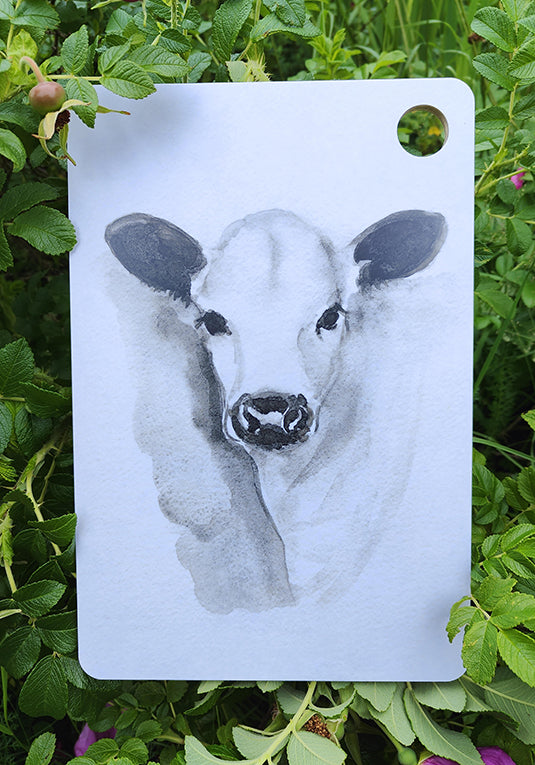 Ateljee Lumimetsä Lapinlehmävasikka – käsinmaalattu tarjoilualusta Posiolta, Lapinlehmä-kuvituksella.