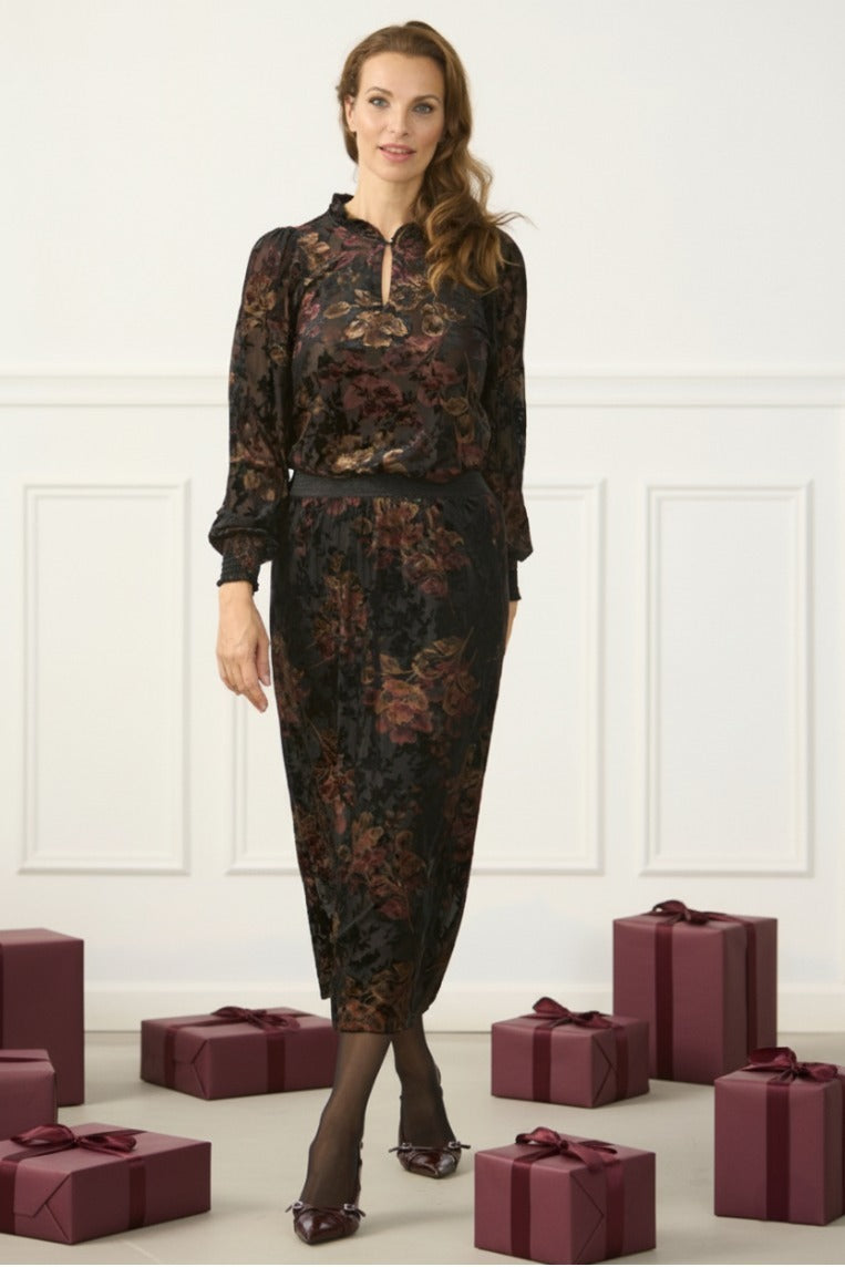 Nellie-pusero, musta läpikuultava pusero kultaisin ja burgundin värisin brodeerauksin – elegantti ja naisellinen valinta juhlaan ja arkeen.