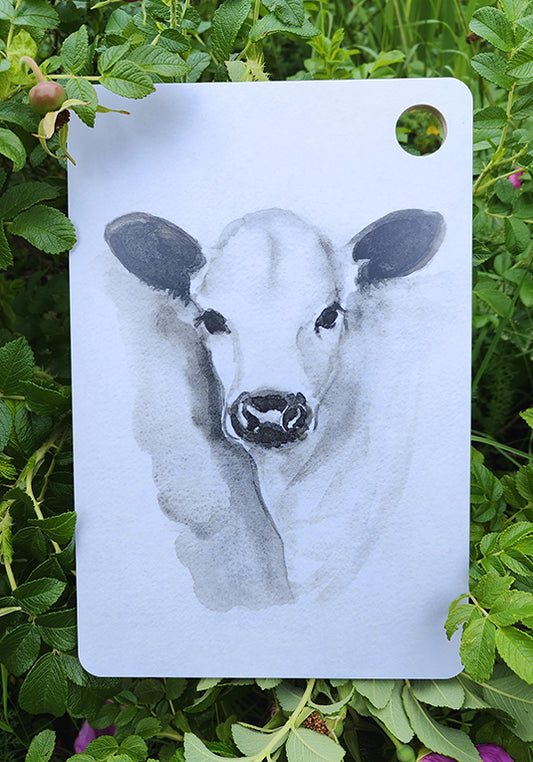 Ateljee Lumimetsä Lapinlehmävasikka – käsinmaalattu tarjoilualusta Posiolta, Lapinlehmä-kuvituksella.