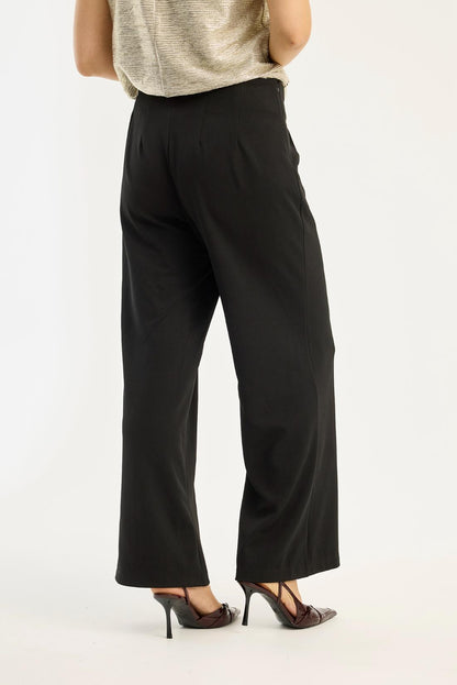 Funny-housut iN FRONT, mustat leveälahkeiset housut korkealla vyötäröllä, sivuvetoketju ja kaunis vyötärön yksityiskohta – elegantit ja tyylikkäät.