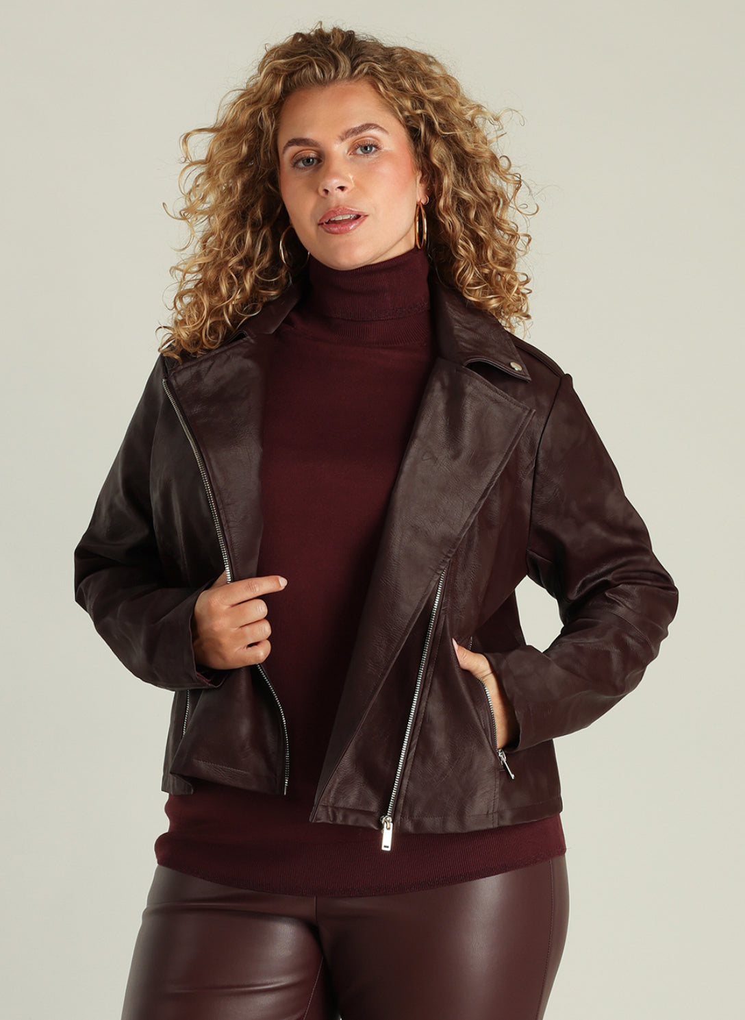 Grace tekonahkatakki burgundynsävyisenä, biker-tyylinen lyhyt takki vinovetoketjulla ja metalliyksityiskohdilla. Tyylikäs ja helppohoitoinen PU-takki.