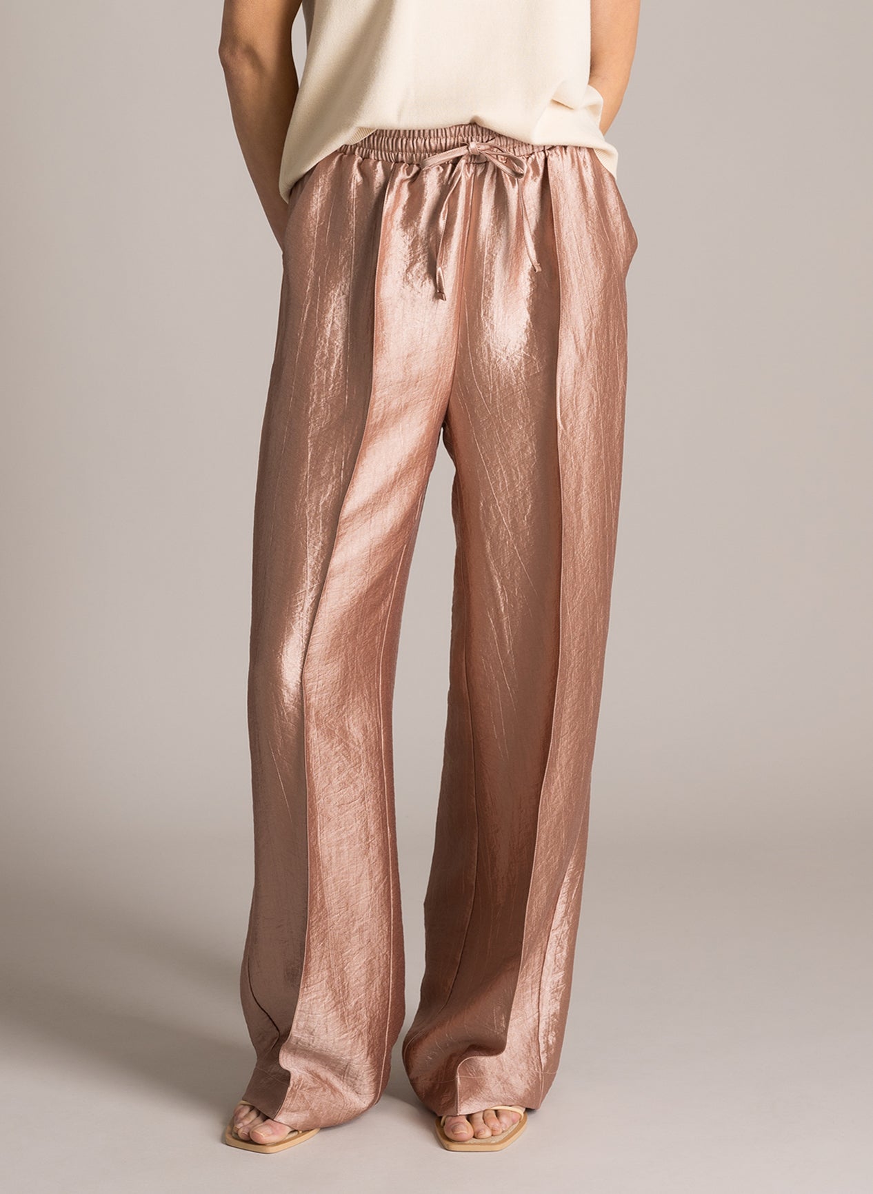 Klara kiiltävät housut suoralla lahkeella, joustava vyötärö ja sivutaskut