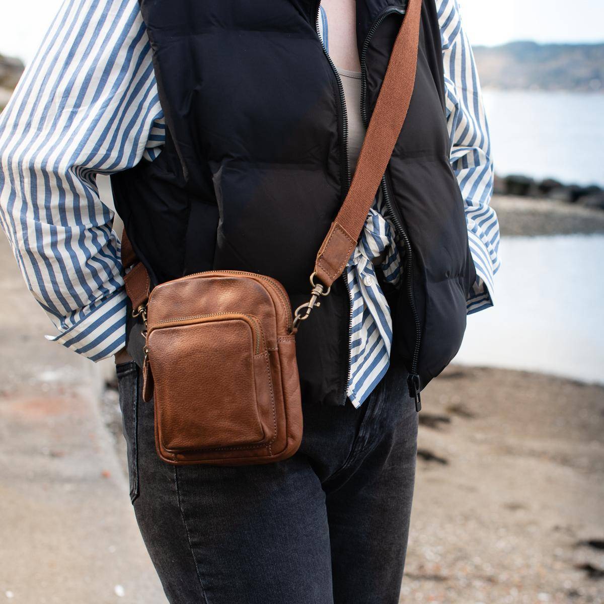 Pieni citynahkalaukku vetoketjulla ja säädettävällä olkahihnalla.