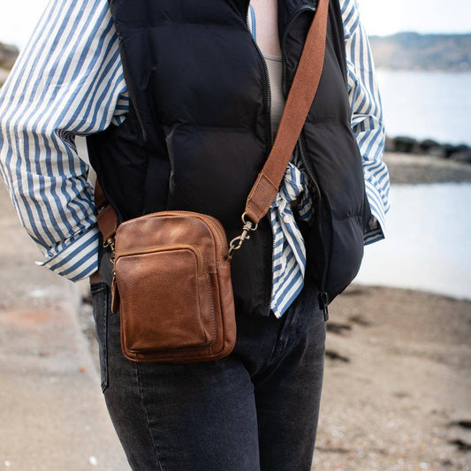 Pieni citynahkalaukku vetoketjulla ja säädettävällä olkahihnalla.