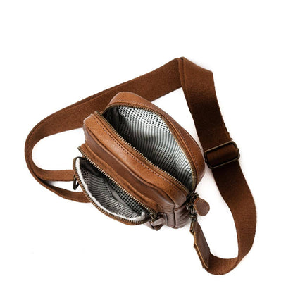 Pieni citynahkalaukku vetoketjulla ja säädettävällä olkahihnalla.