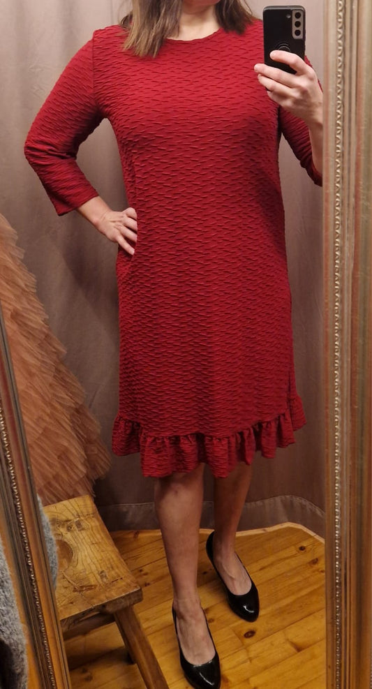 Niccolein punainen kohokuvioitu juhlamekko, täyspitkät hihat ja röyhelö miehustassa.