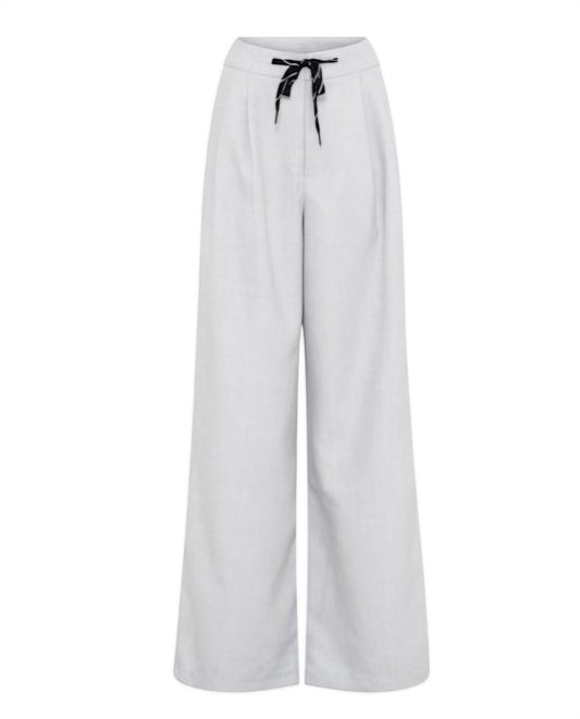 Harmaat kevyet housut leveillä lahkeilla ja nyörivyötäröllä.