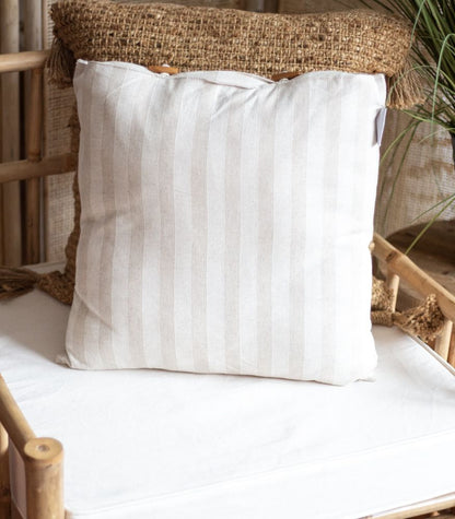 Raidallinen pellavatyyny vaaleissa sävyissä, koristeelliset puunapit, luonnollinen sisustustyyny