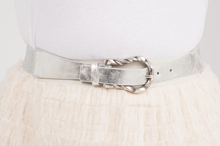 Kapea joustava vyö hopeanvärisellä soljella, sopii mekon, tunikan tai ponchon päälle, elastaani- ja keinonahkamateriaalia.