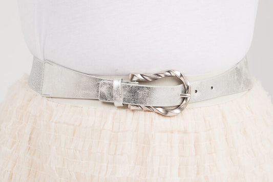 Kapea joustava vyö hopeanvärisellä soljella, sopii mekon, tunikan tai ponchon päälle, elastaani- ja keinonahkamateriaalia.