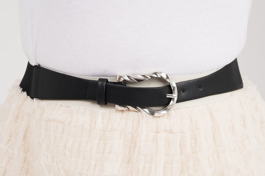 Kapea joustava vyö hopeanvärisellä soljella, sopii mekon, tunikan tai ponchon päälle, elastaani- ja keinonahkamateriaalia.