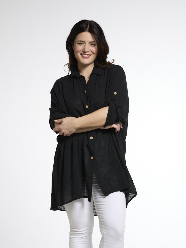 Naisten pitkä musta puuvillapaita, 100 % puuvillakangasta, väljä istuvuus ja rennot käännettävät hihat.